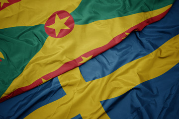 waving colorful flag of sweden and national flag of grenada.