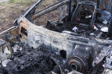 burned out fast car parked on the road in the city. car leftovers. molten vehicle