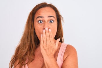 Middle age mature woman standing over white isolated background cover mouth with hand shocked with shame for mistake, expression of fear, scared in silence, secret concept