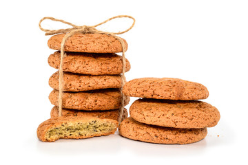 Homemade cookies. Five sweet cookie made from oatmeal flour, stacked and tied with jute rope and three and hakf next. Tasty biscuit close up isolated on white background.