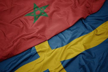 waving colorful flag of sweden and national flag of morocco.