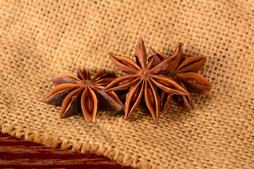 Star anise. Three star anise fruits. Macro close up on the jute burlap canvas.