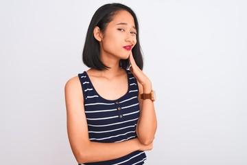 Young chinese woman wearing striped t-shirt standing over isolated white background touching mouth with hand with painful expression because of toothache or dental illness on teeth. Dentist concept.