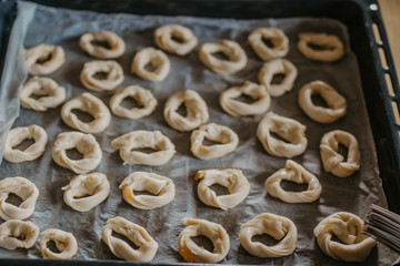 cookies or donut-shaped sweets on the tray prepared for cooking