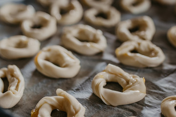 cookies or donut-shaped sweets on the tray prepared for cooking