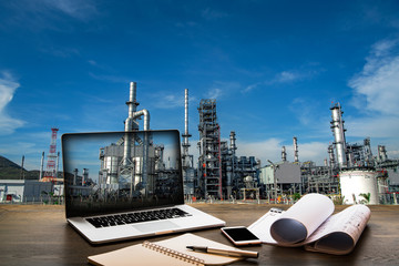 Double exposure Engineers holding safety helmet in arms and holding walk talky in hands with oil and gas refinery background on industry concept