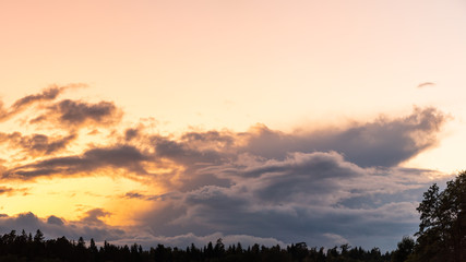 Sunset over forest with pastel colors sky and colorful clouds