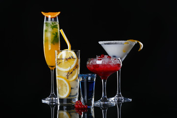 Different tasty cocktails on dark background