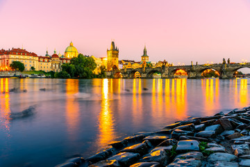 Fototapeta premium Vltava River and illuminated Charles Bridge at evening time. Prague, Czech Republic