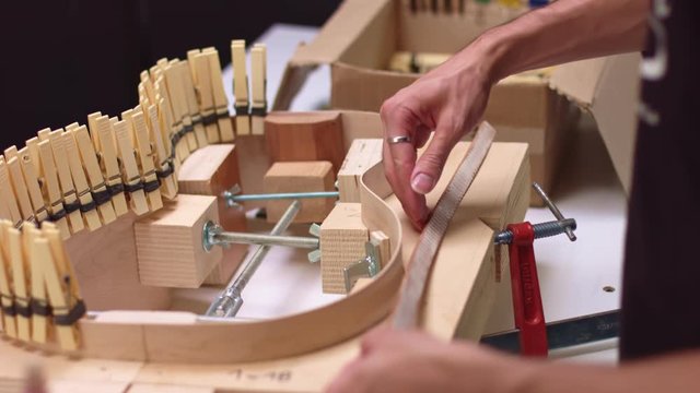 Guitar maker glues half lining on acoustic guitar