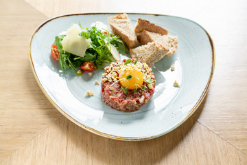 Beef tartar in the restaurant. Tasty dish on a plate. Restaurant menu.