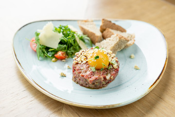 Beef tartar in the restaurant. Tasty dish on a plate. Restaurant menu.