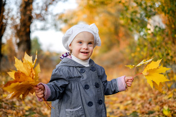girl with down syndrome in the autumn in the park
