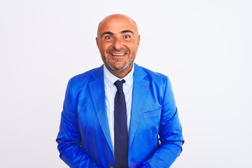 Middle age businessman wearing suit standing over isolated white background with hands together and crossed fingers smiling relaxed and cheerful. Success and optimistic