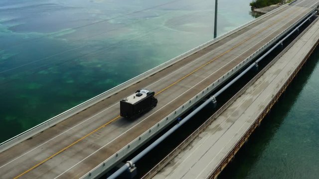RV driving bridge in Key West, aerial of Florida, deep blue water, travel around US