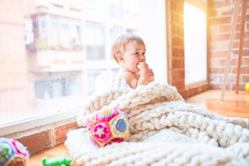 Beautiful toddler sitting on the blanket at kindergarten