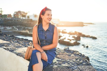 Beautiful young woman walking on beach promenade enjoying ocean view smiling happy on summer vacation