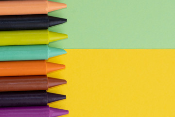 Back to school, minimalism concept. School supplies. Wax crayons on trendy yellow green color paper...