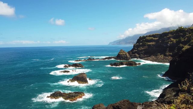 4K video of natural volcano lava pools in Seixal. The wild waves of the Atlantic Ocean are breaking on the shores of Madeira Island, Portugal.