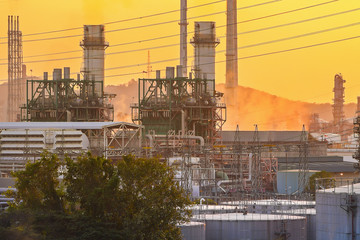 Oil and gas industrial refinery zone,Detail of equipment oil pipeline steel with valve from large oil storage tank at sunset.