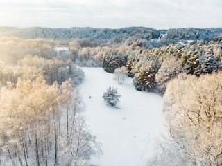 Beautiful aerial view of snow covered pine forests. Rime ice and hoar frost covering trees. Scenic winter landscape in Vilnius, Lithuania.