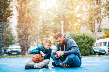 Father and his son enjoying together on basketball court.