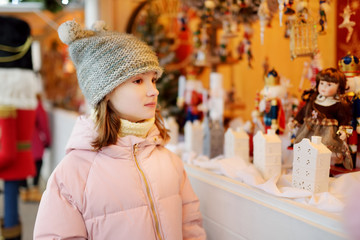 Young girl looking at Christmas dolls and decorations sold at Christmas market in Vilnius,...