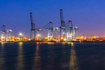 Obraz premium Close up view Silhouette Cargo freight ship and cargo container working with crane at port area,Logistic Import Export.