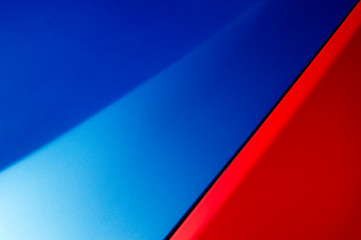 Car bodywork detail, hood and fender of sport sedan painted in blue and red colors, automobile...