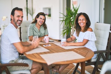 Beautiful family sitting on terrace drinking cup of coffee speaking and smiling