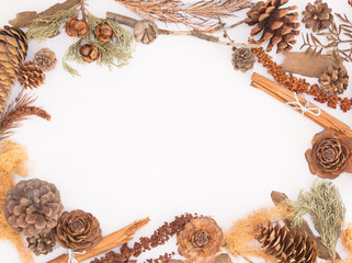 Autumn natural decorations frame with copy space for text isolated on white background: pine cones, cinnamon sticks, leaves and branches / For weddings, fall, winter and holidays