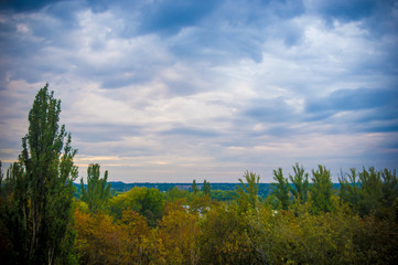 Fototapeta premium Autumn urban landscape on a Sunny day - yellow and colorful autumn trees, the sky with clouds with autumn haze