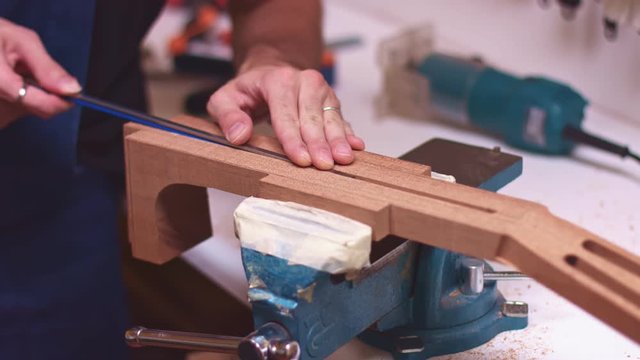 Guitar maker insert truss rod in guitar neck