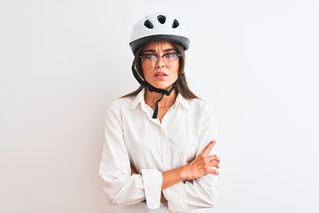 Beautiful businesswoman wearing glasses and bike helmet over isolated white background skeptic and nervous, disapproving expression on face with crossed arms. Negative person.