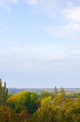 Autumn urban landscape on a Sunny day - yellow and colorful autumn trees, the sky with clouds with autumn haze