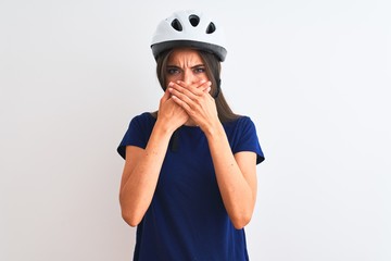 Young beautiful cyclist woman wearing security bike helmet over isolated white background shocked covering mouth with hands for mistake. Secret concept.