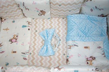 Beige bed linen set for a newborn baby's cot. Beige textile with zigzags and a pattern of bears....