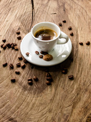 coffee beans behind cup of black coffee