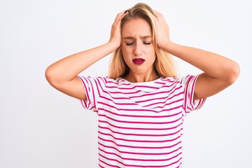 Young beautiful woman wearing pink striped t-shirt standing over isolated white background suffering from headache desperate and stressed because pain and migraine. Hands on head.