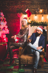 Christmas decorations and gift box on wooden background. Portrait of surprised and funny couple. Christmas couple in love.