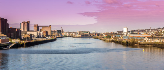 Naklejka premium Cork Ireland city center harbor panorama view morning sunrise cold weather calm river water reflection buildings colors 