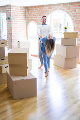 Young beautiful couple dancing  at new home around cardboard boxes