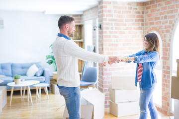 Young beautiful couple dancing  at new home around cardboard boxes