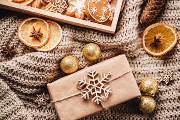 Christmas and New Year traditions concept. Gingerbread cookies, decorations, gift boxes and knitted blanket