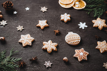 Christmas background with homemade gingerbread cookies on black table, copy space. Festive food, New Year celebration traditions