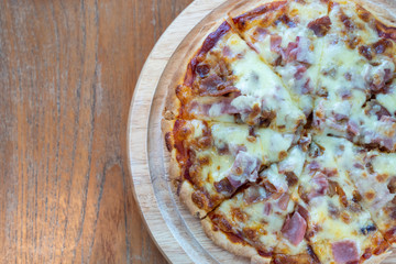 Hot pizza slice with dripping ham sausage and mozzarella cheese.