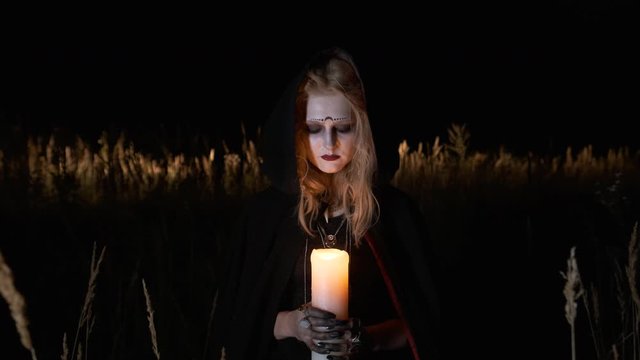 Halloween Image. Portrait Of Young Witch. Witch Holds Candle In Her Hands.