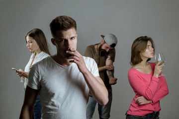 Four people displaying addiction to alcohol, nicotine, drugs and gadgets. Epidemic, addiction...