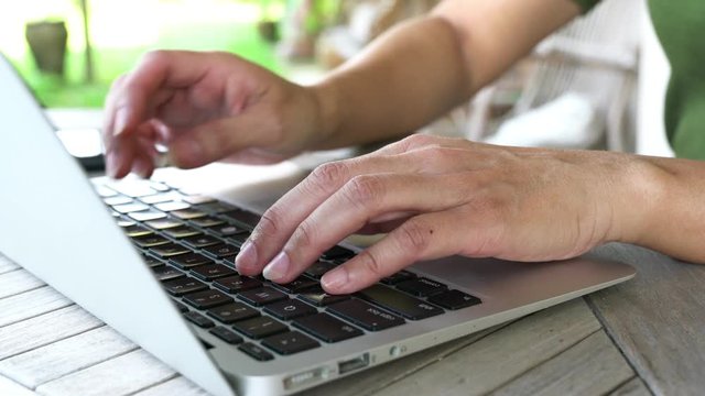 Typing on keyboard, closeup on woman fingers