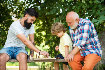 Young boy with father and grandfather enjoying together in park. Generations men. Boy with father and grandfather. Senior man workout in rehabilitation center.